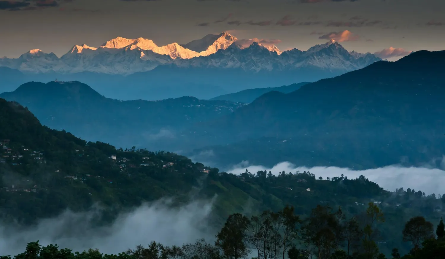 Layered Himalayan foothills with distant snow peaks